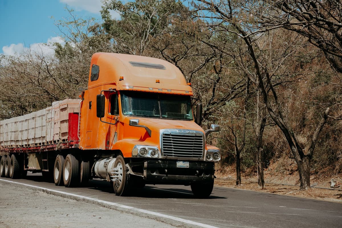 a line of semi-trucks unloading rolls of sod
