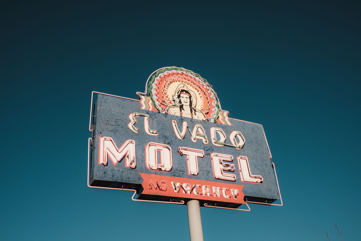 a dusty wifi router with a tiny neon 'VACANCY' sign on top