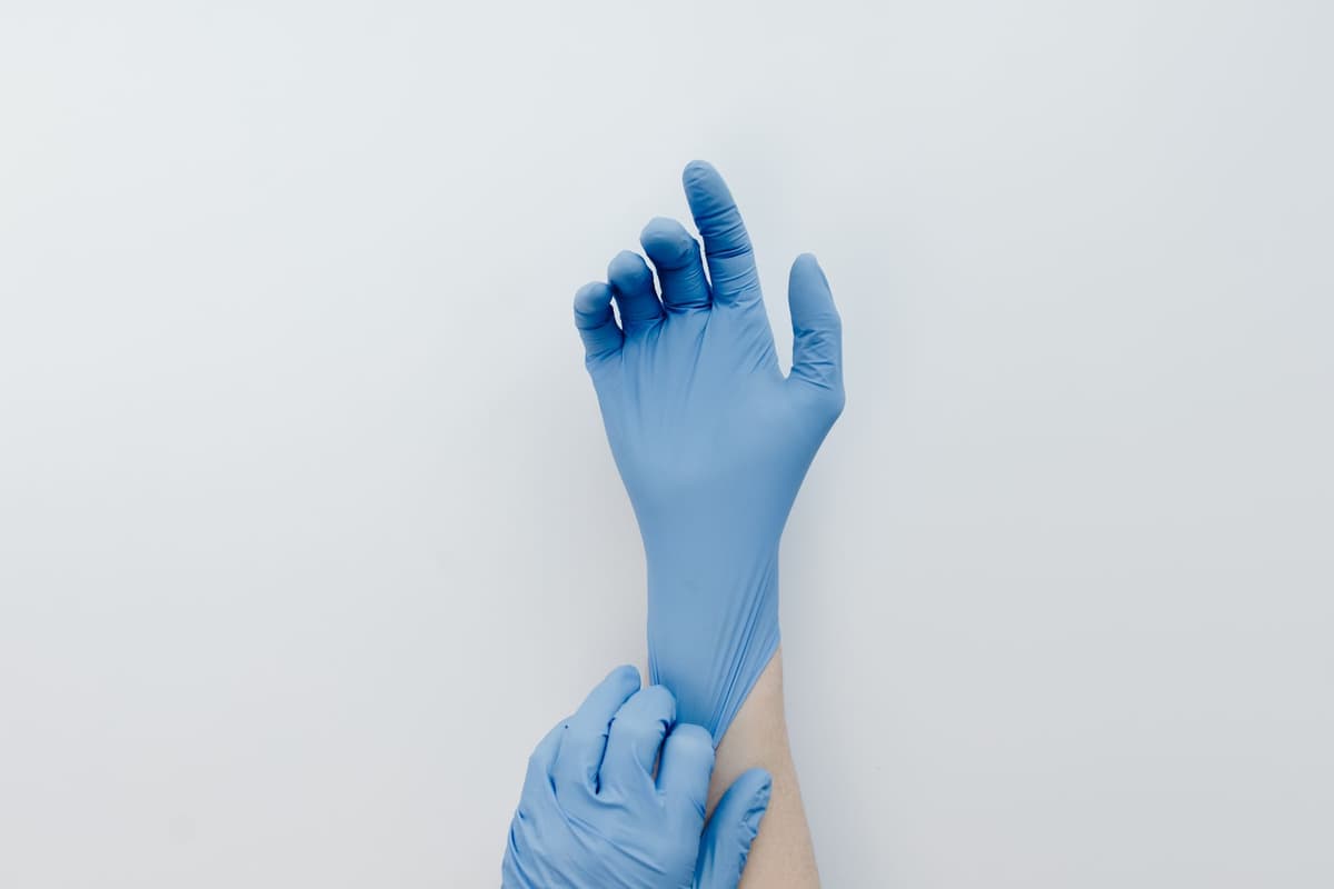 a mountain of discarded blue nitrile gloves in a dumpster