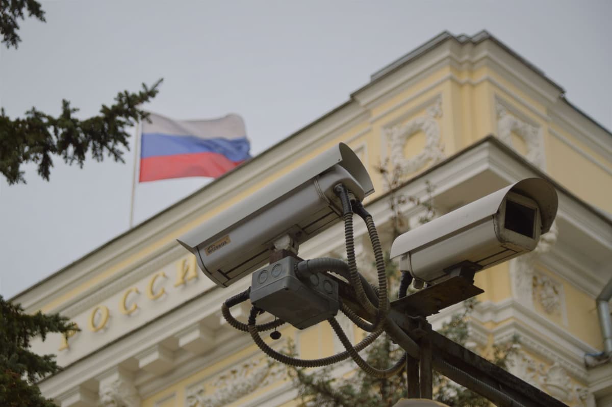 a single security camera painted with three different national flags