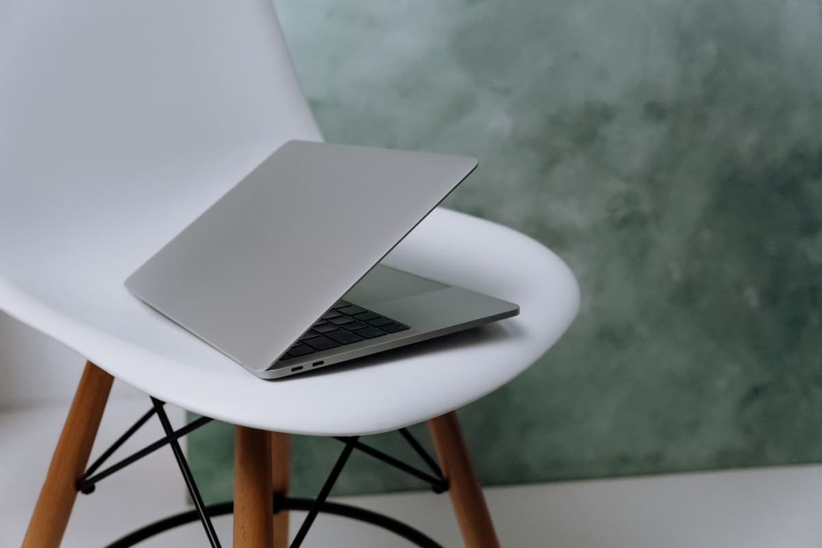 a wooden stool next to a standard office chair on a white background