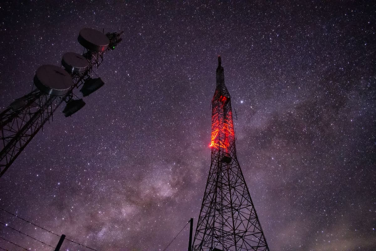 a large satellite dish against a dark starry sky
