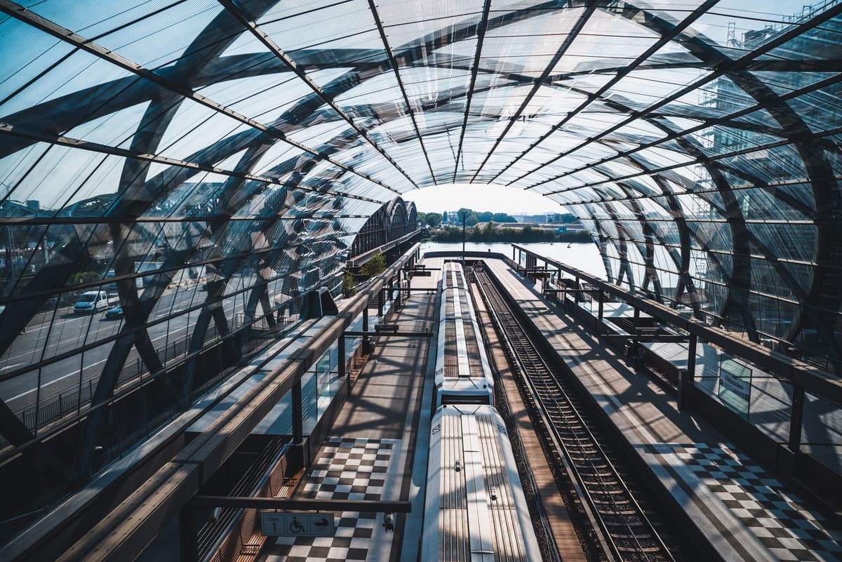 a modern glass train station reflecting a sunrise