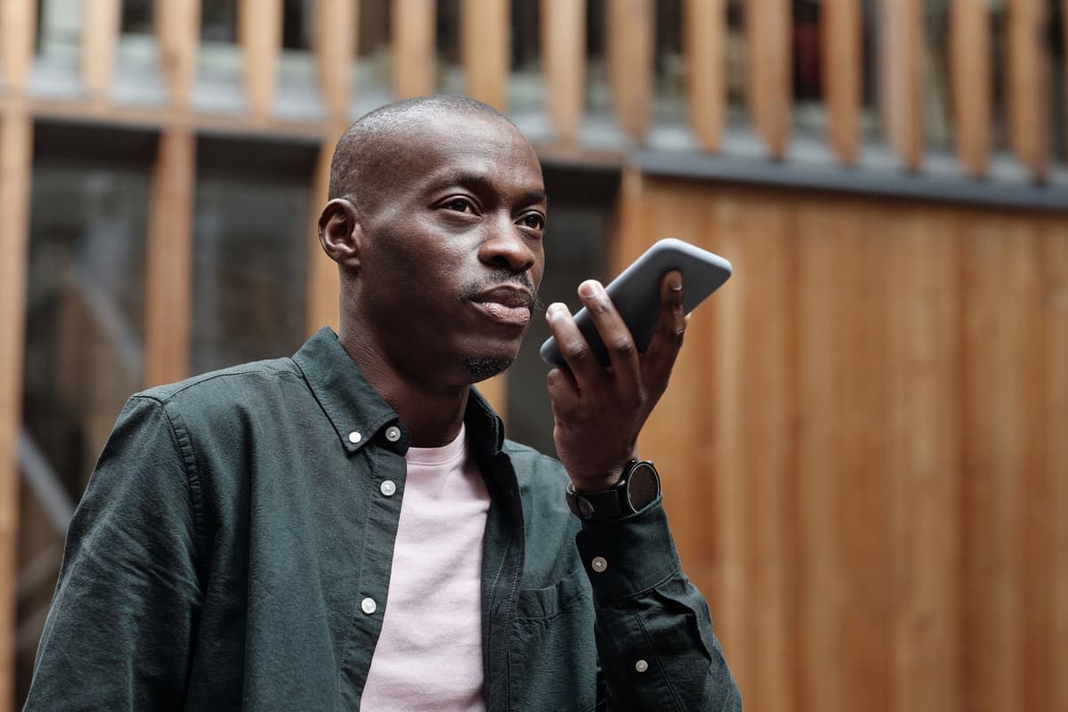 a person speaking into a smartphone in a quiet, sunlit room