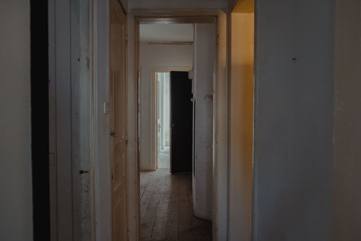 a heavy steel vault door slightly ajar in a dark room