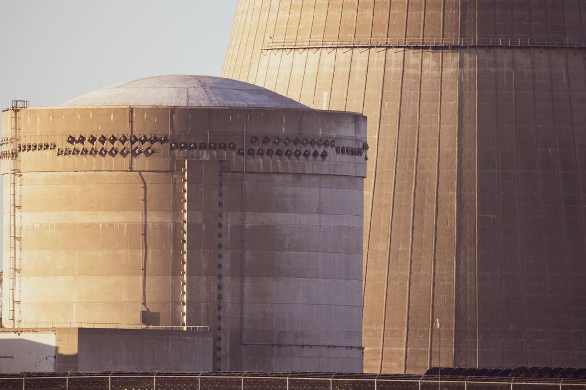 a single glowing computer mouse plugged directly into a massive concrete nuclear cooling tower