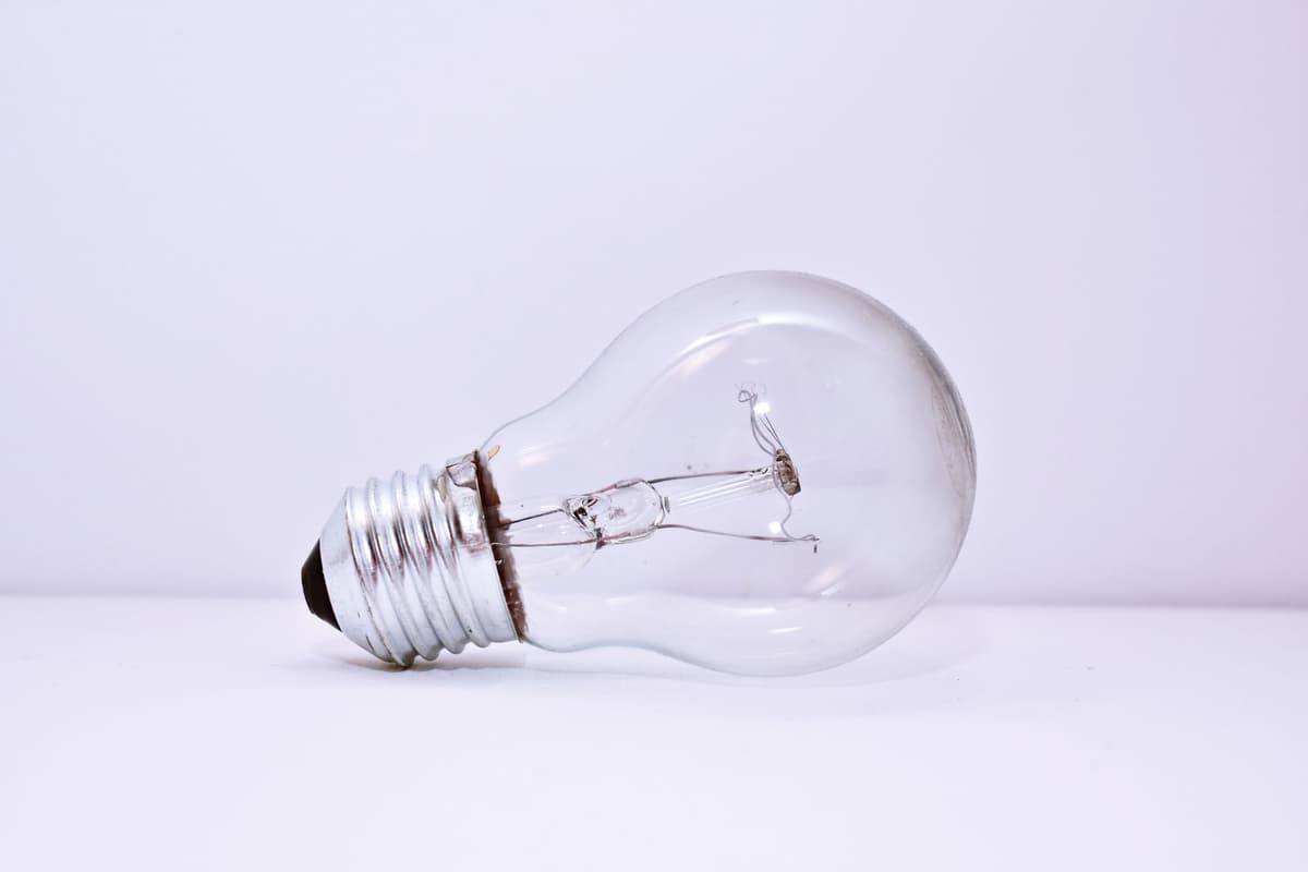 a single lightbulb hanging over an old desktop monitor