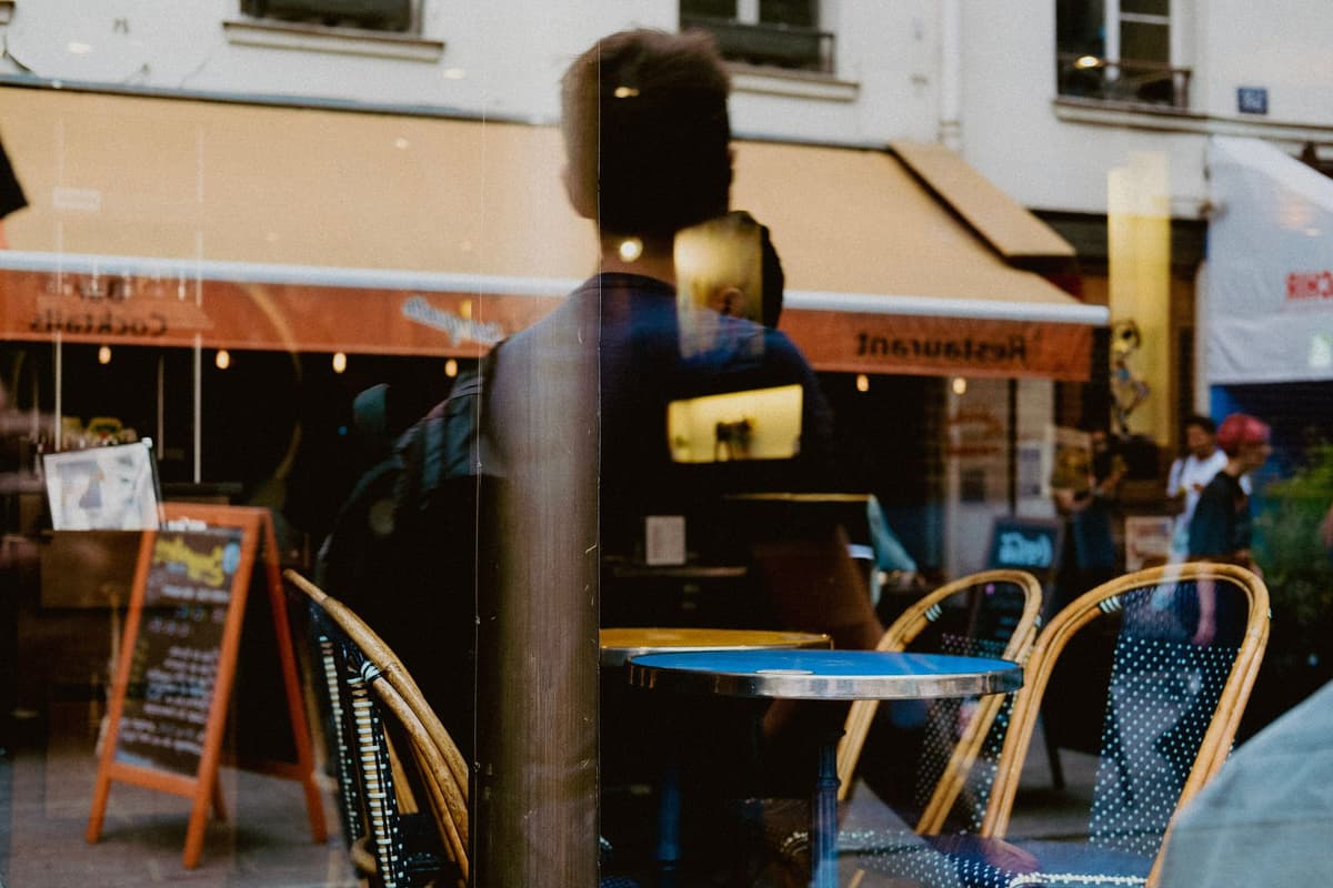 a person wearing sleek transparent earplugs in a busy bistro