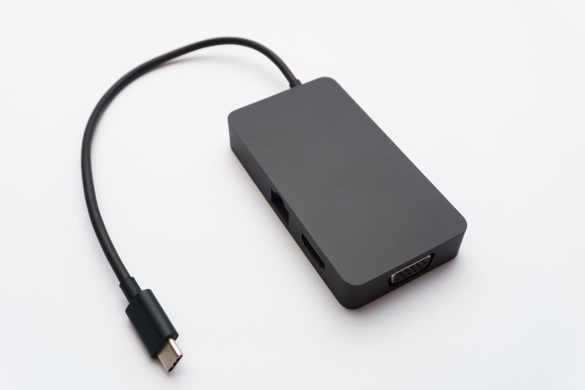 a row of five identical white USB-C cables on a black desk