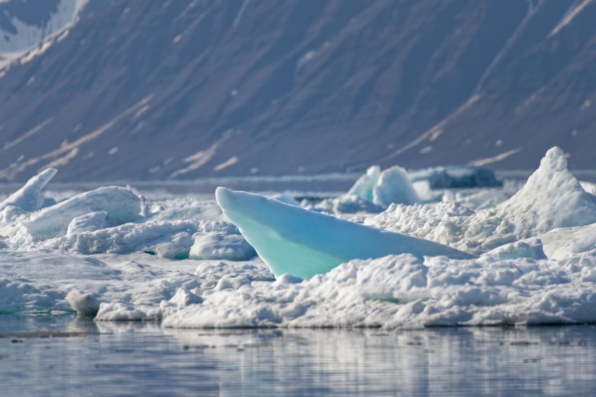 a massive white ice stupa melting slowly under a harsh mountain sun