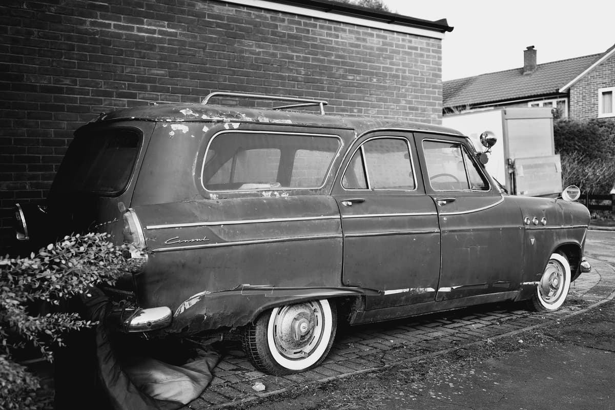 a dusty station wagon with mismatched antennas taped to the roof