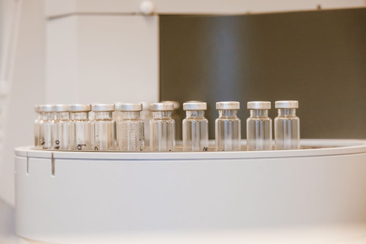 a sterile laboratory bench holding a single glowing server blade next to glass vials