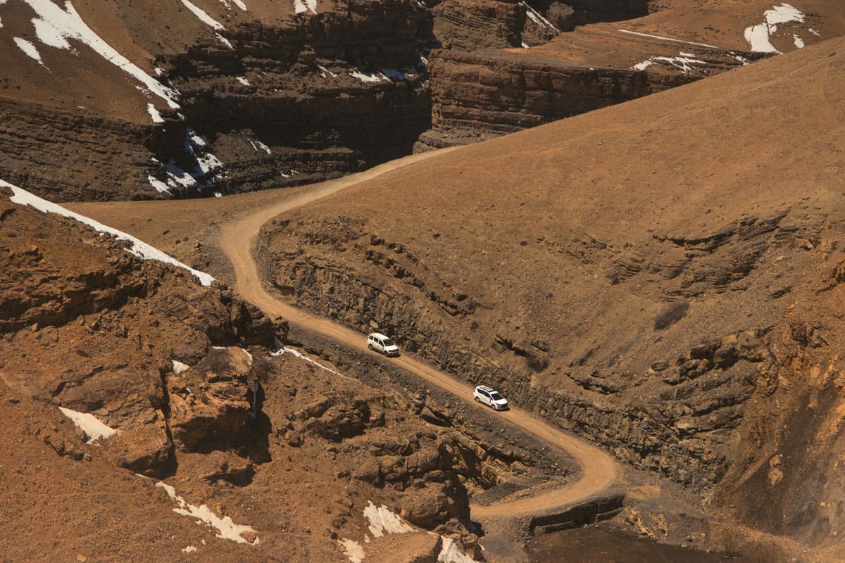 military trucks parked on a dusty mountain pass
