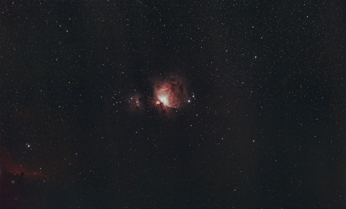 a vintage brass telescope pointed at a neon nebula