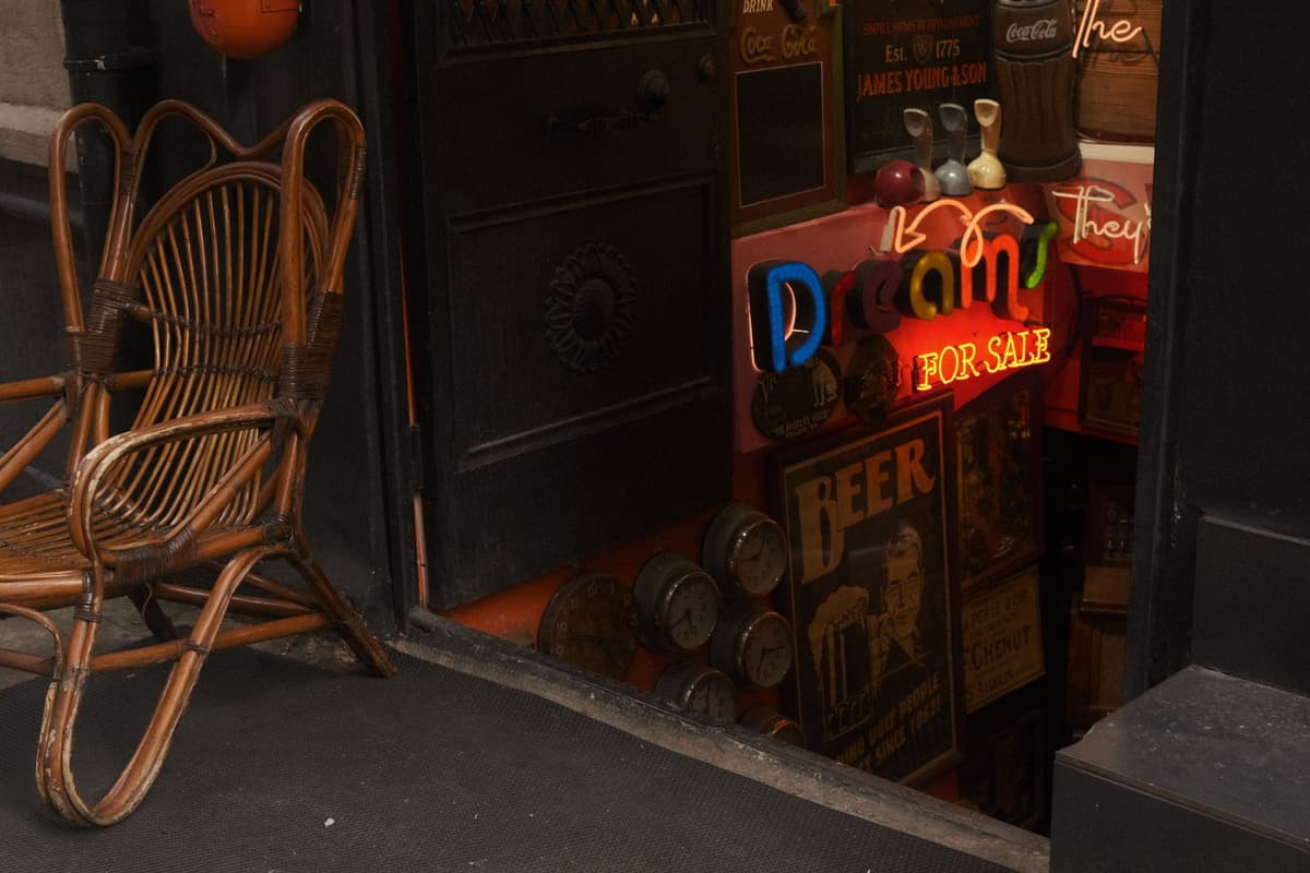 an old brass telescope pointing at a neon sign