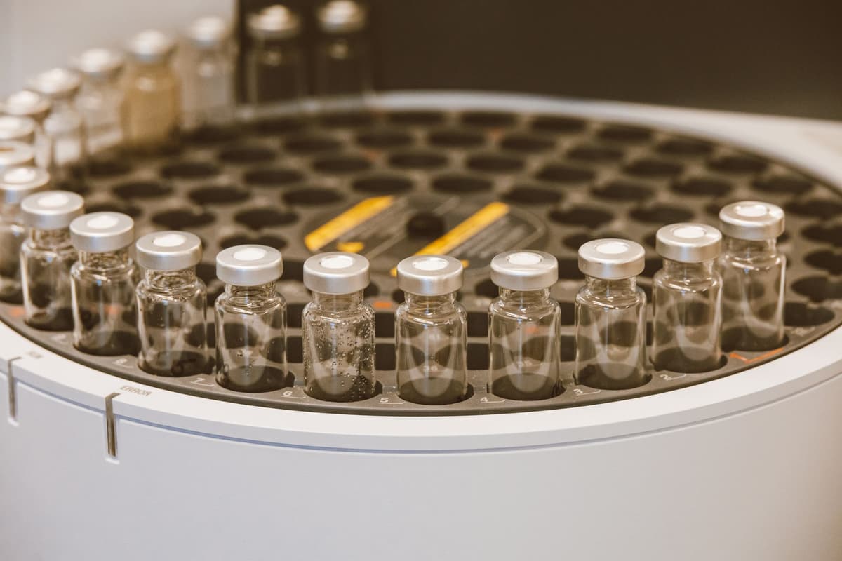a sterile white lab table with a DNA vial beside a pair of worn soccer cleats