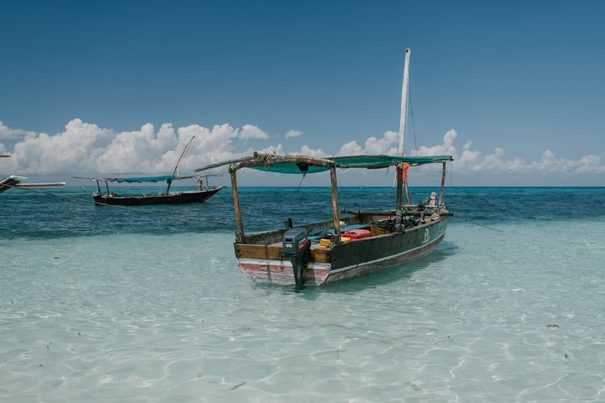 a small wooden fishing boat floating over clear turquoise water