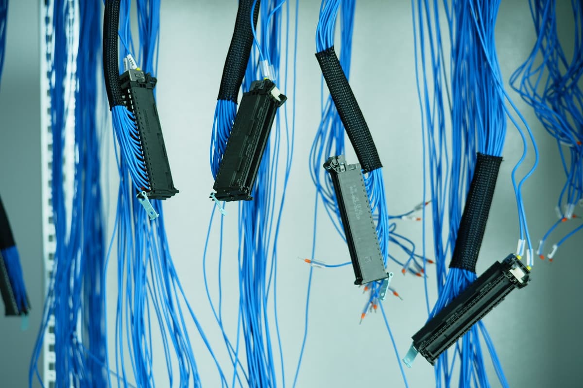 a thick bundle of industrial server cables behind a locked steel cage