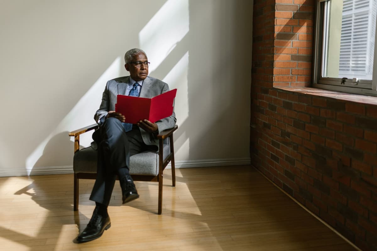 a businessman sitting uncomfortably close to a wall